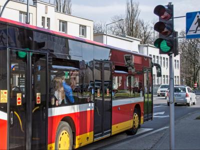 Zdjęcie przedstawiające autobus miejski przejeżdżający na zielonym świetle.